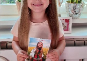 Klara pozuje z pocztówką wydaną z okazji Bożego Ciała!