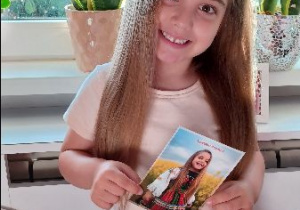 Klara pozuje z pocztówką wydaną z okazji Bożego Ciała!
